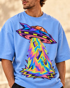 Angled close-up of the Arcade Anomaly UFO print on a baby blue French terry tee