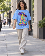 Woman walking down a city street in the Arcade Anomaly baby blue French terry oversized tee