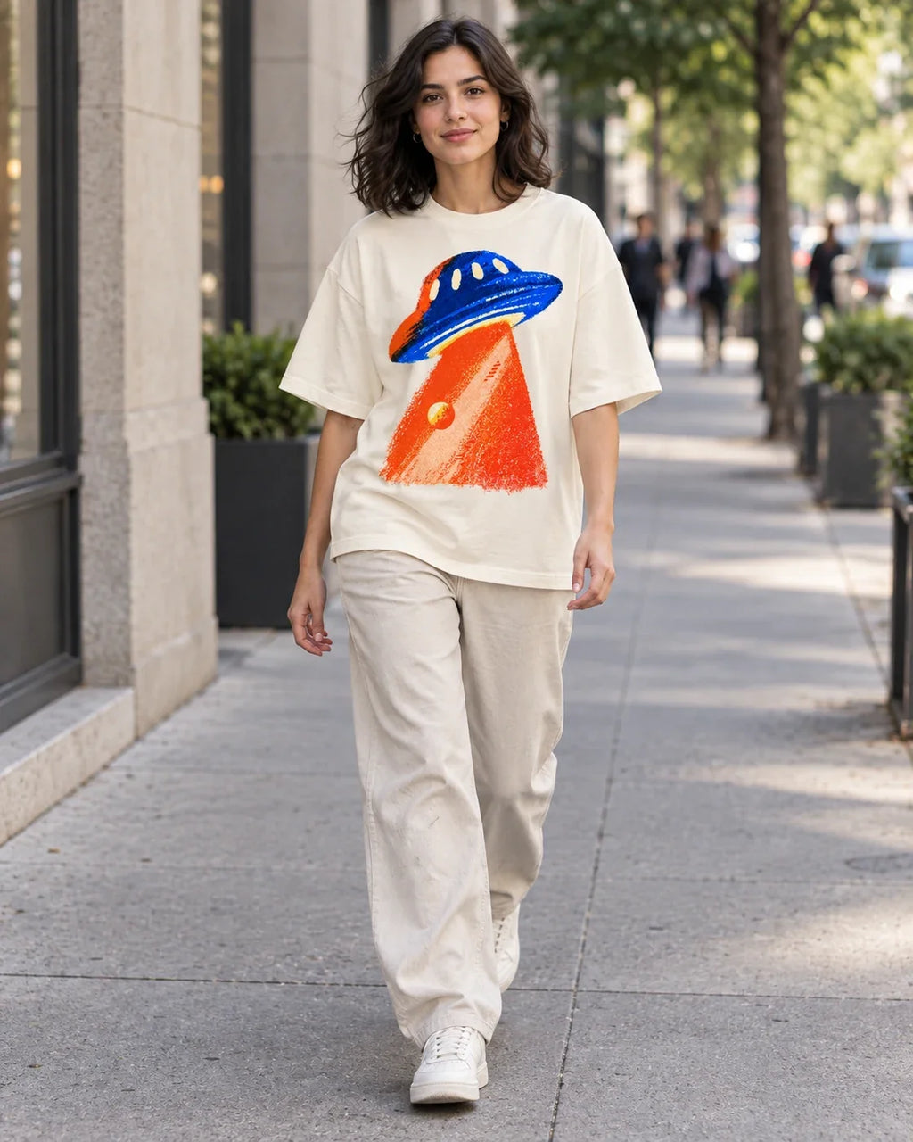 Woman walking down a city street in the Cobalt Ember off-white French terry oversized tee
