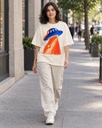Woman walking down a city street in the Cobalt Ember off-white French terry oversized tee