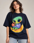 Woman in a navy blue oversized French terry t-shirt printed with a green alien hugging a red star on a crescent moon