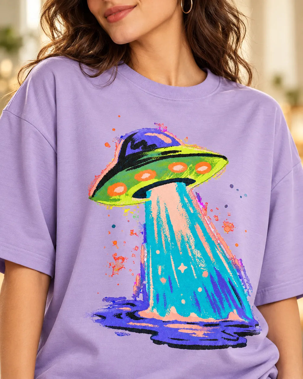 Angled close-up of the Electric Lagoon UFO print on a lavender French terry tee