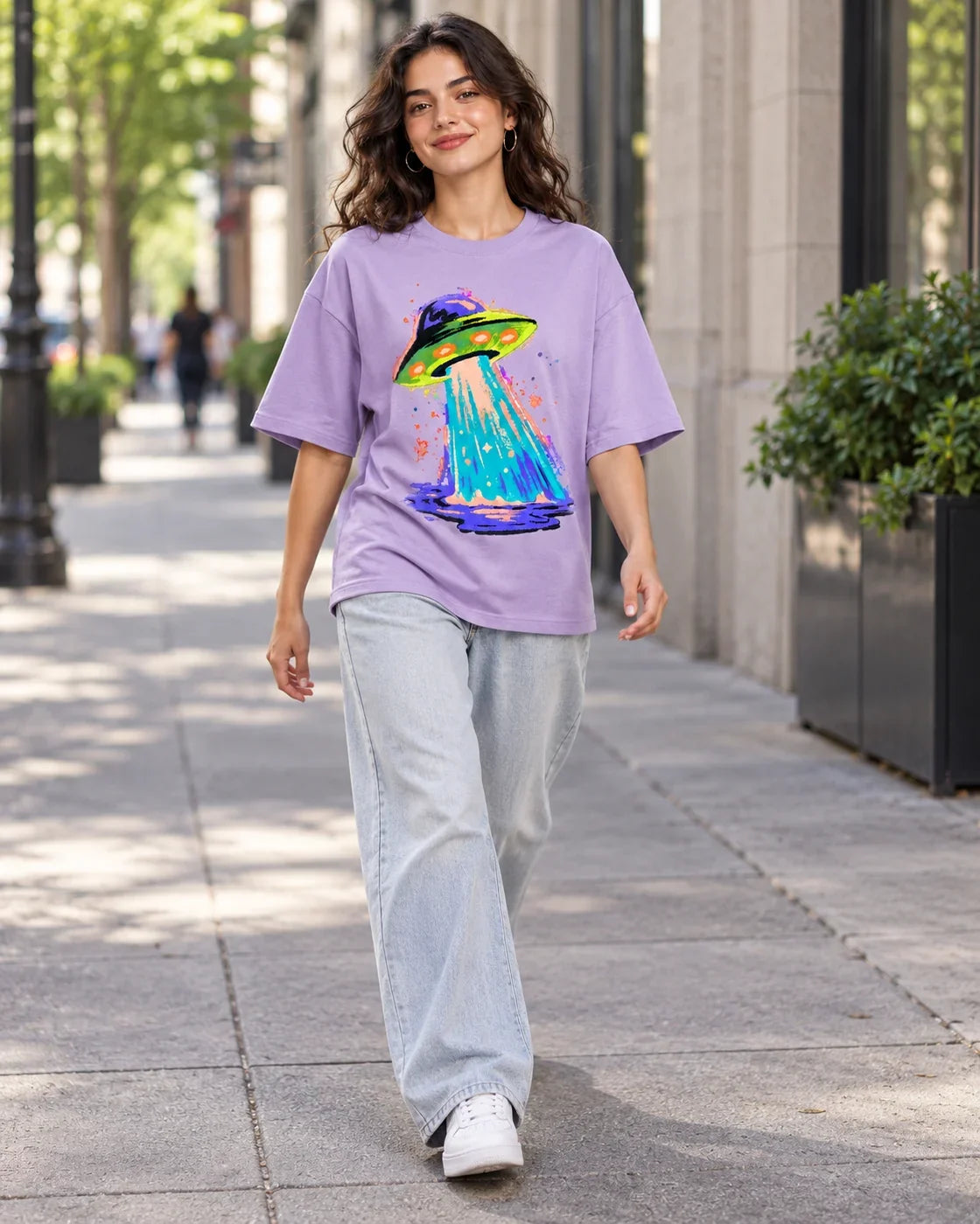 Woman walking down a city street in the Electric Lagoon lavender French terry oversized tee