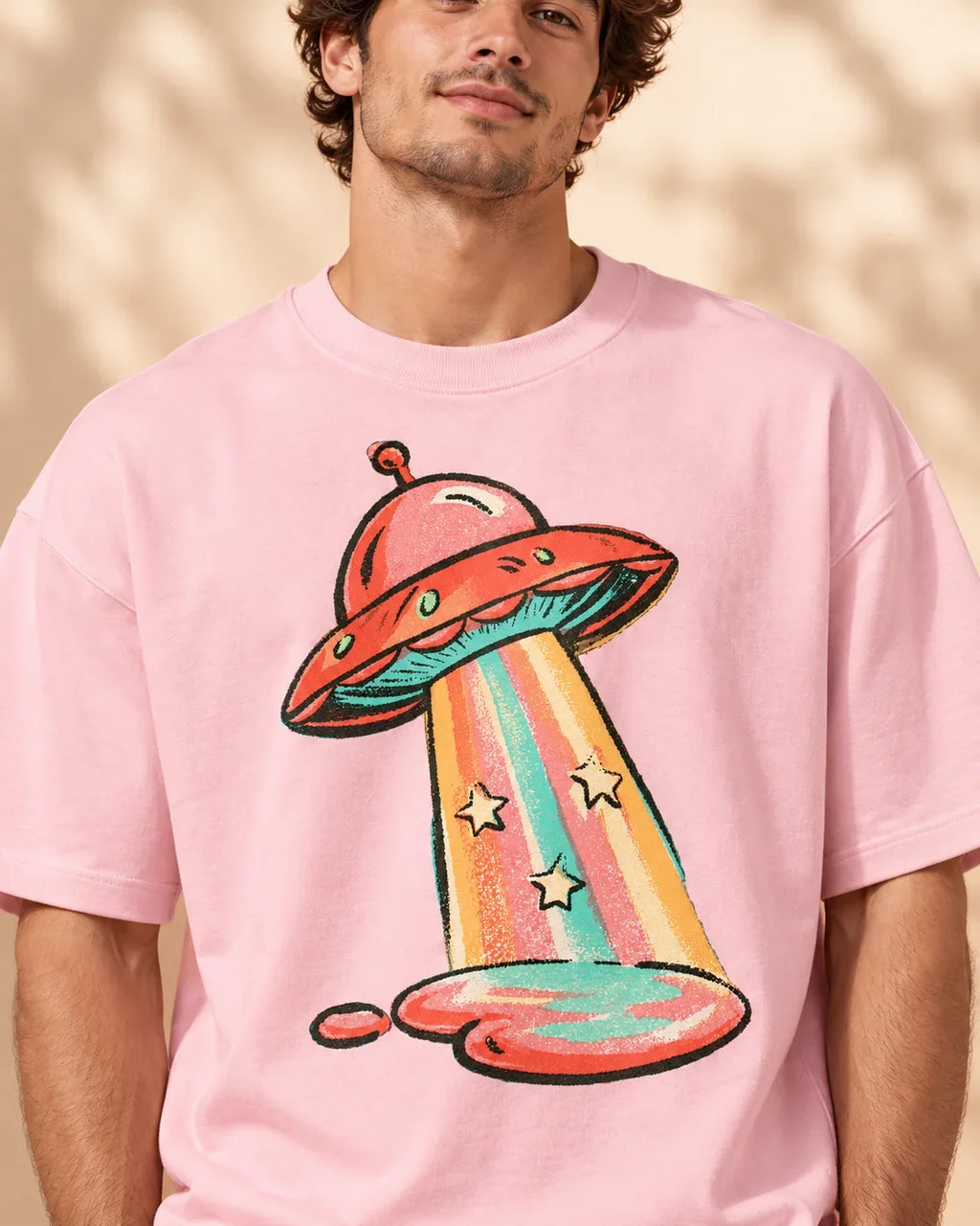 Candy Orbit print close-up: cherry-red saucer with a candy-striped, star-sprinkled beam on light baby pink French terry