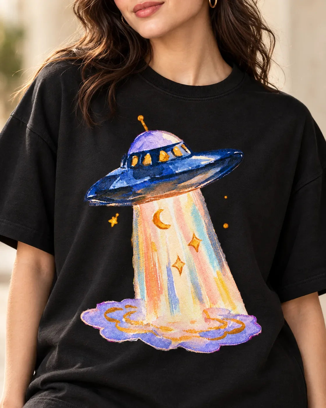 Angled close-up of the Lunar Haze UFO print on a black French terry tee