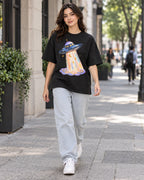 Woman walking down a city street in the Lunar Haze black French terry oversized tee