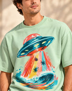 Angled close-up of the Tidal Transit UFO print on a jade French terry tee