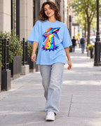Woman walking down a city street in the Prism Strike baby blue French terry oversized tee