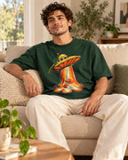 Man relaxing on a couch in the Solar Petals UFO oversized tee, bottle green