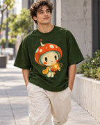 Man on a street in a bottle green oversized French terry t-shirt with a mushroom sprite in a scarf holding a glowing spark