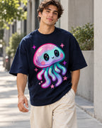 Man on a street in a navy blue oversized French terry t-shirt with a pastel jellyfish with starry eyes and pink sparkles