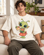Man on a sofa in an off-white oversized French terry t-shirt with a green alien in an apron pouring tea from a teapot