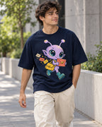 Man on a street in a navy blue oversized French terry t-shirt with a lilac alien with a yellow satchel delivering letters