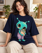 Woman on a sofa in a navy blue oversized French terry t-shirt with an aqua alien hugging a jar of pink clouds and stars