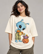Woman in an off-white oversized French terry t-shirt printed with a blue alien watering a cactus in a meteor-like pot