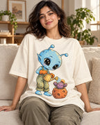 Woman on a sofa in an off-white oversized French terry t-shirt with a blue alien watering a cactus in a meteor-like pot