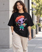 Woman on a street in a black oversized French terry t-shirt with a purple alien in a beret painting a ringed planet