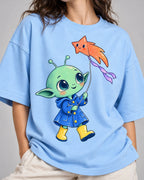 Close-up of a green alien in a raincoat flying a star-shaped kite printed on a baby blue oversized French terry t-shirt