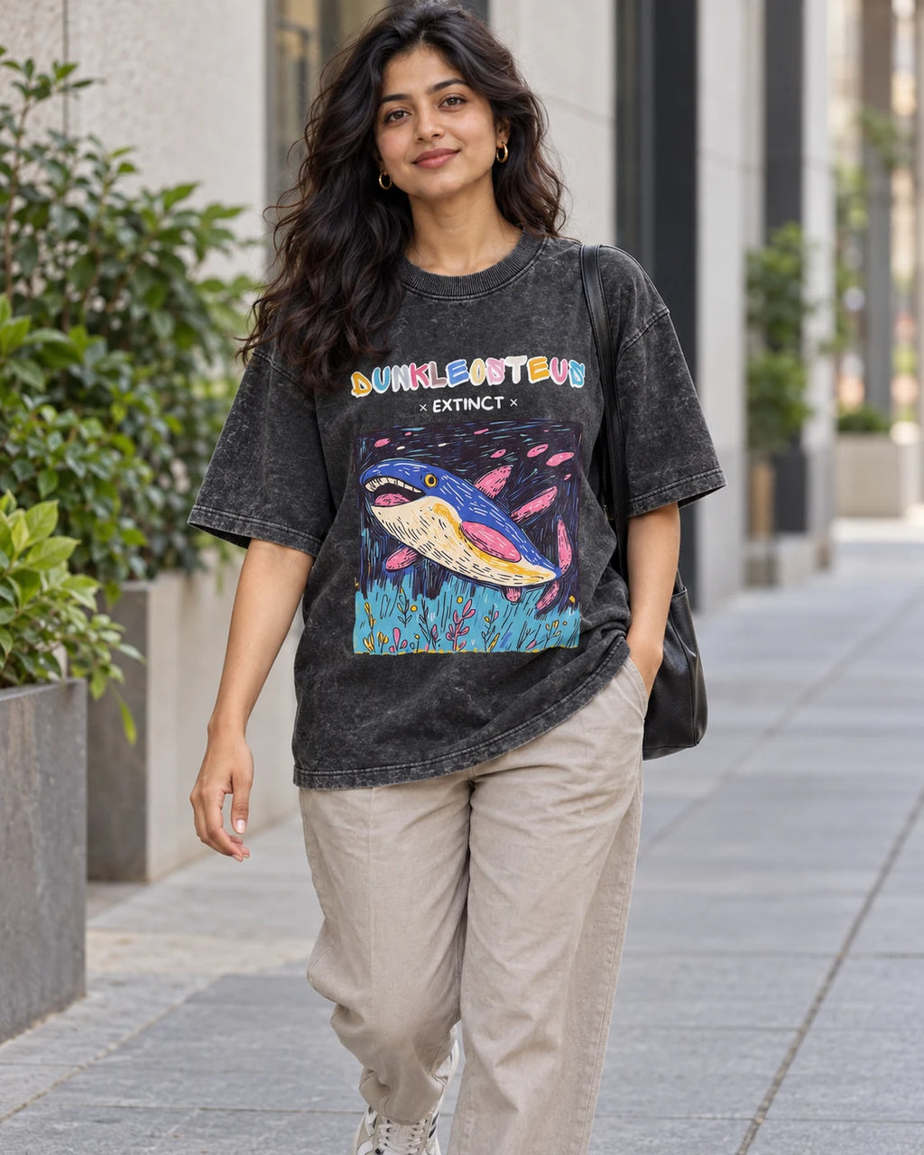 Model wearing the Dunkleosteus black acid wash oversized T-shirt on a city street, Fourth Dimension Club
