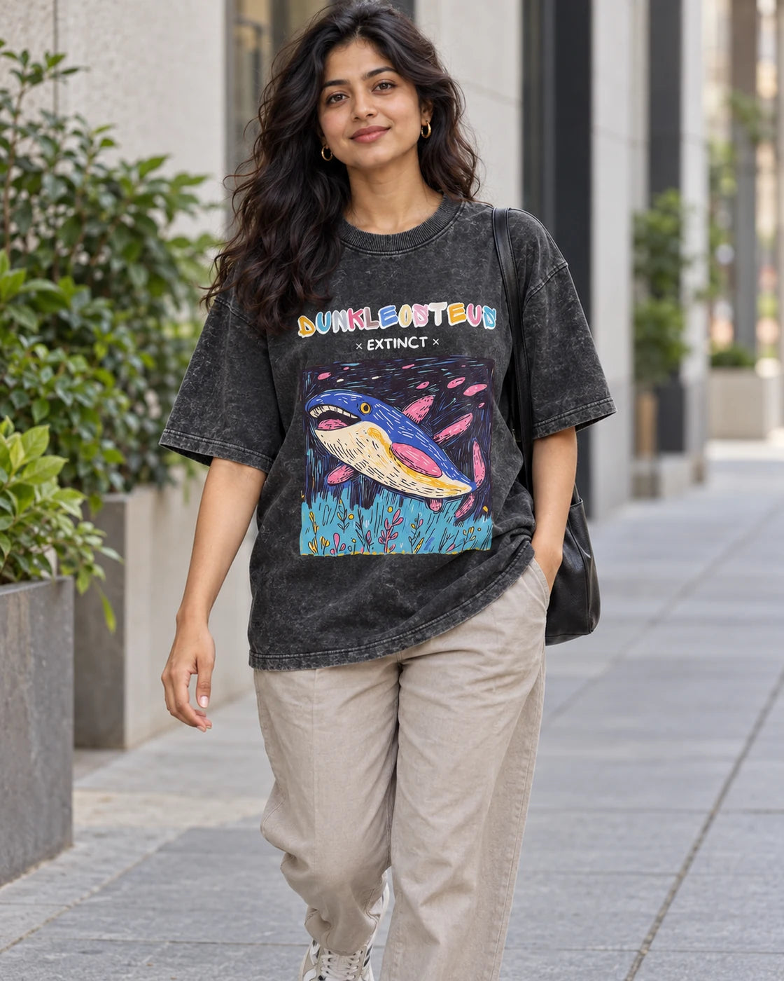 Model wearing the Dunkleosteus black acid wash oversized T-shirt on a city street, Fourth Dimension Club