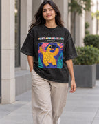 Model wearing the Giant Ground Sloth black acid wash oversized T-shirt on a city street, Fourth Dimension Club