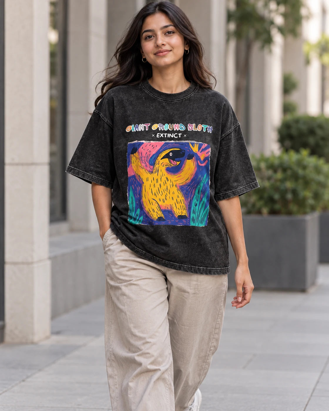 Model wearing the Giant Ground Sloth black acid wash oversized T-shirt on a city street, Fourth Dimension Club
