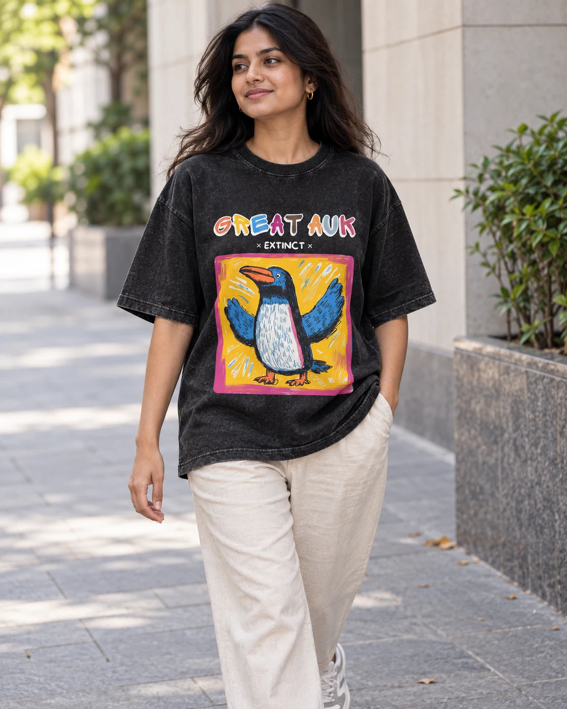 Model wearing the Great Auk black acid wash oversized T-shirt on a city street, Fourth Dimension Club