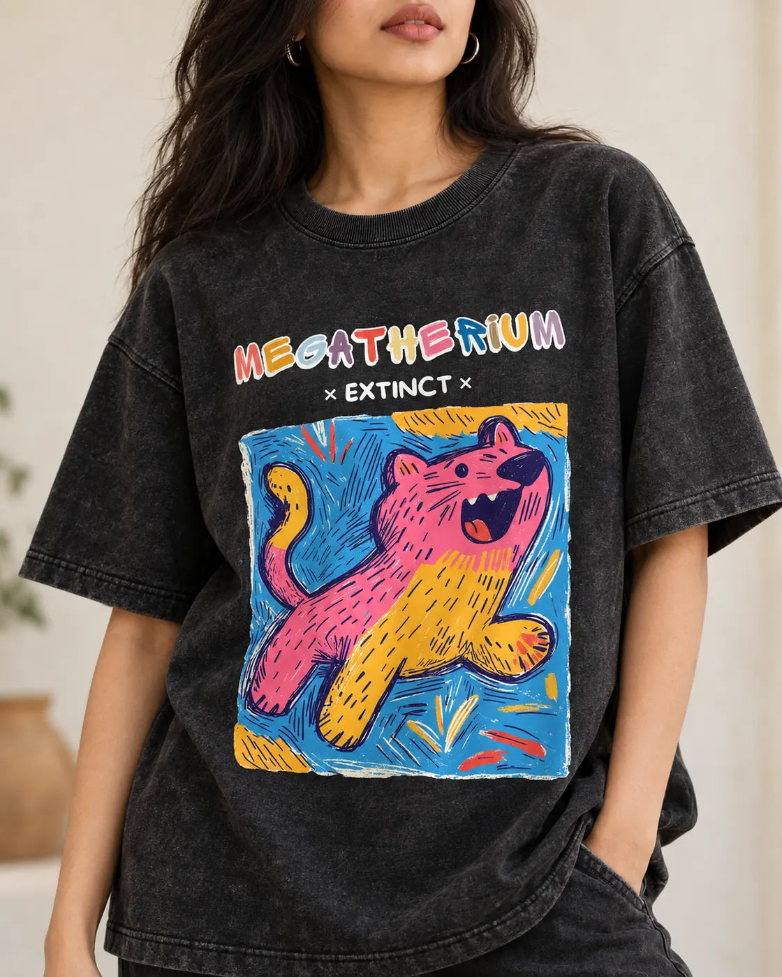 Close-up of the Megatherium Ancient Archives print on a black acid wash oversized T-shirt