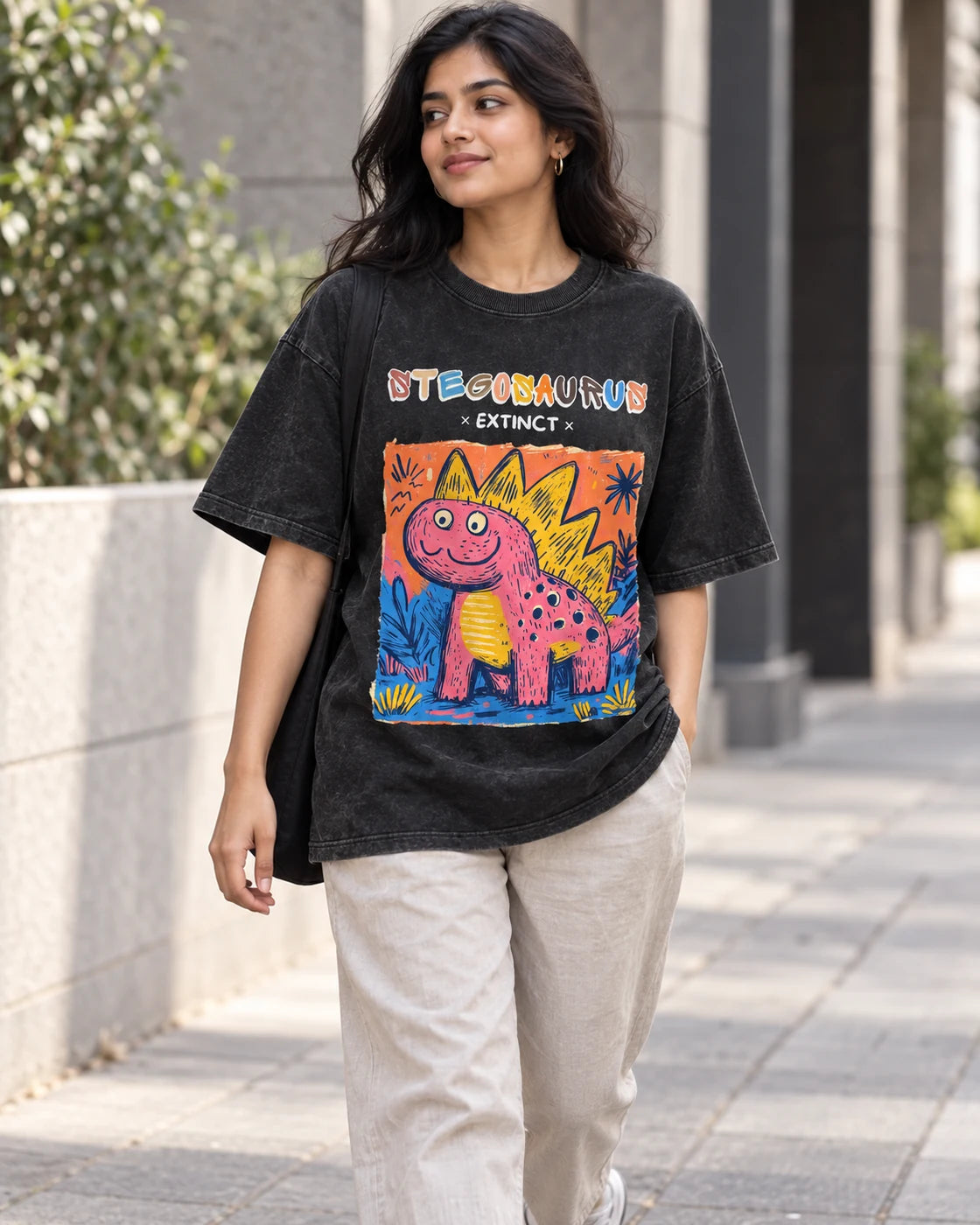 Model wearing the Stegosaurus black acid wash oversized T-shirt on a city street, Fourth Dimension Club