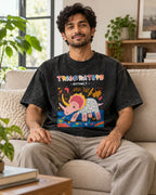 Model wearing the Triceratops black acid wash oversized T-shirt seated on a sofa, Fourth Dimension Club