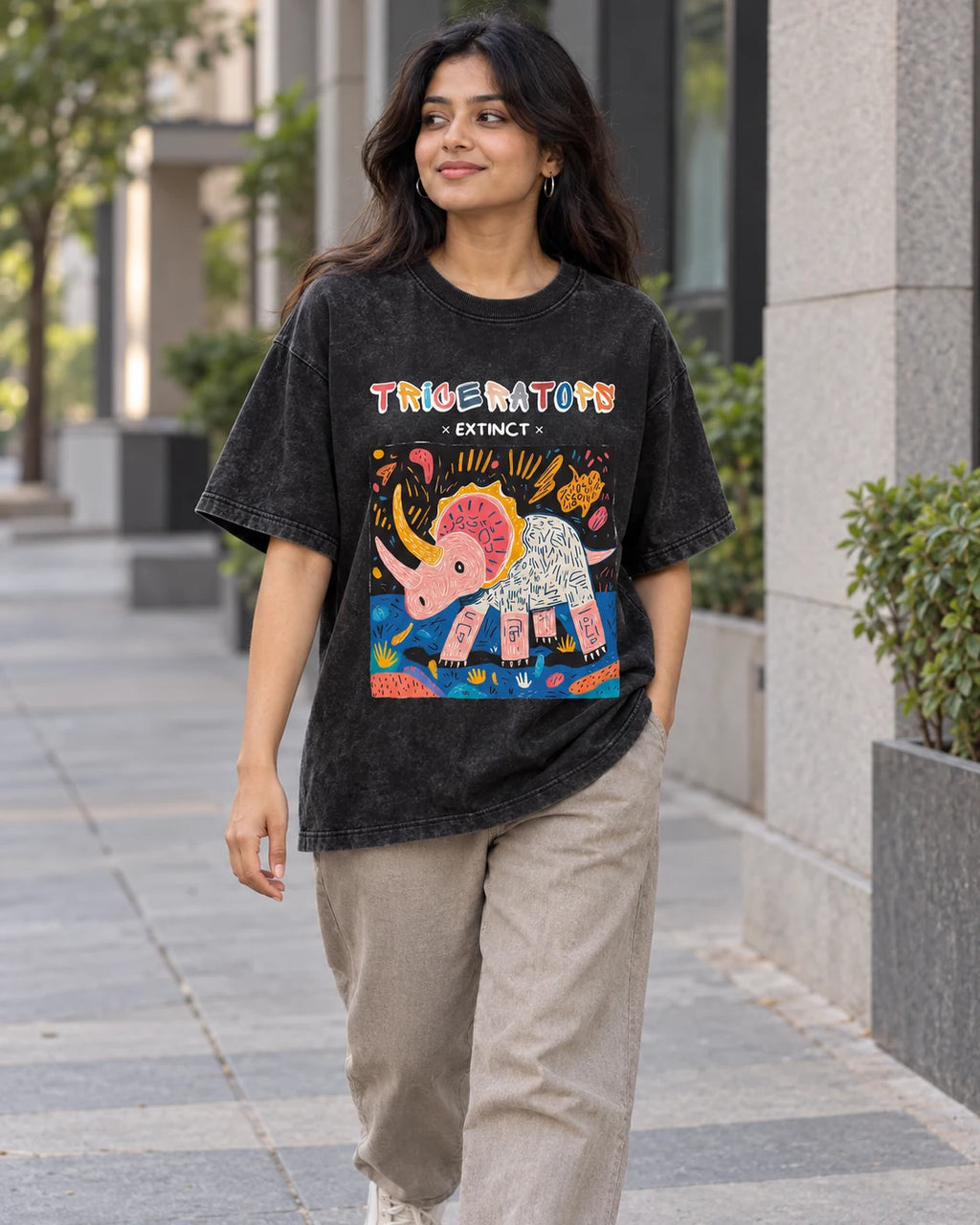 Model wearing the Triceratops black acid wash oversized T-shirt on a city street, Fourth Dimension Club