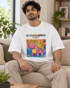 Model wearing the Stegosaurus white oversized French terry T-shirt seated on a sofa, Fourth Dimension Club