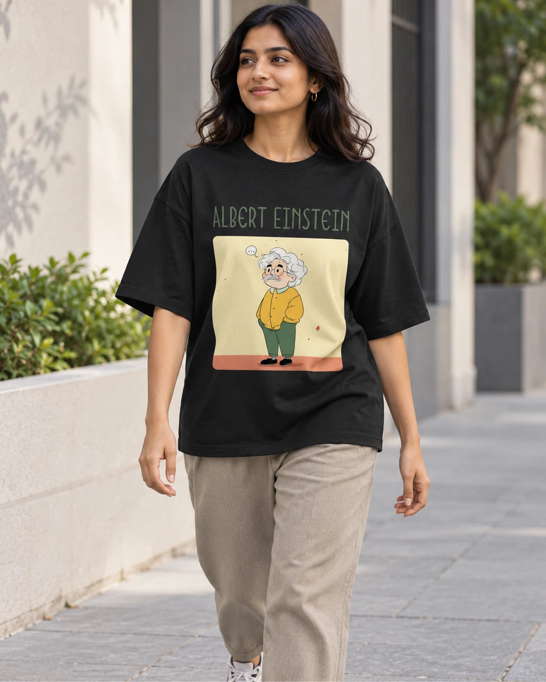 Model wearing the Albert Einstein Genius Doodles oversized French terry T-shirt by Fourth Dimension Club on a city street