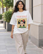 Model wearing the Frida Kahlo Genius Doodles oversized French terry T-shirt by Fourth Dimension Club on a city street