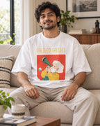 Model wearing the Galileo Galilei Genius Doodles oversized French terry T-shirt by Fourth Dimension Club, seated on a sofa