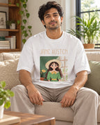 Model wearing the Jane Austen Genius Doodles oversized French terry T-shirt by Fourth Dimension Club, seated on a sofa