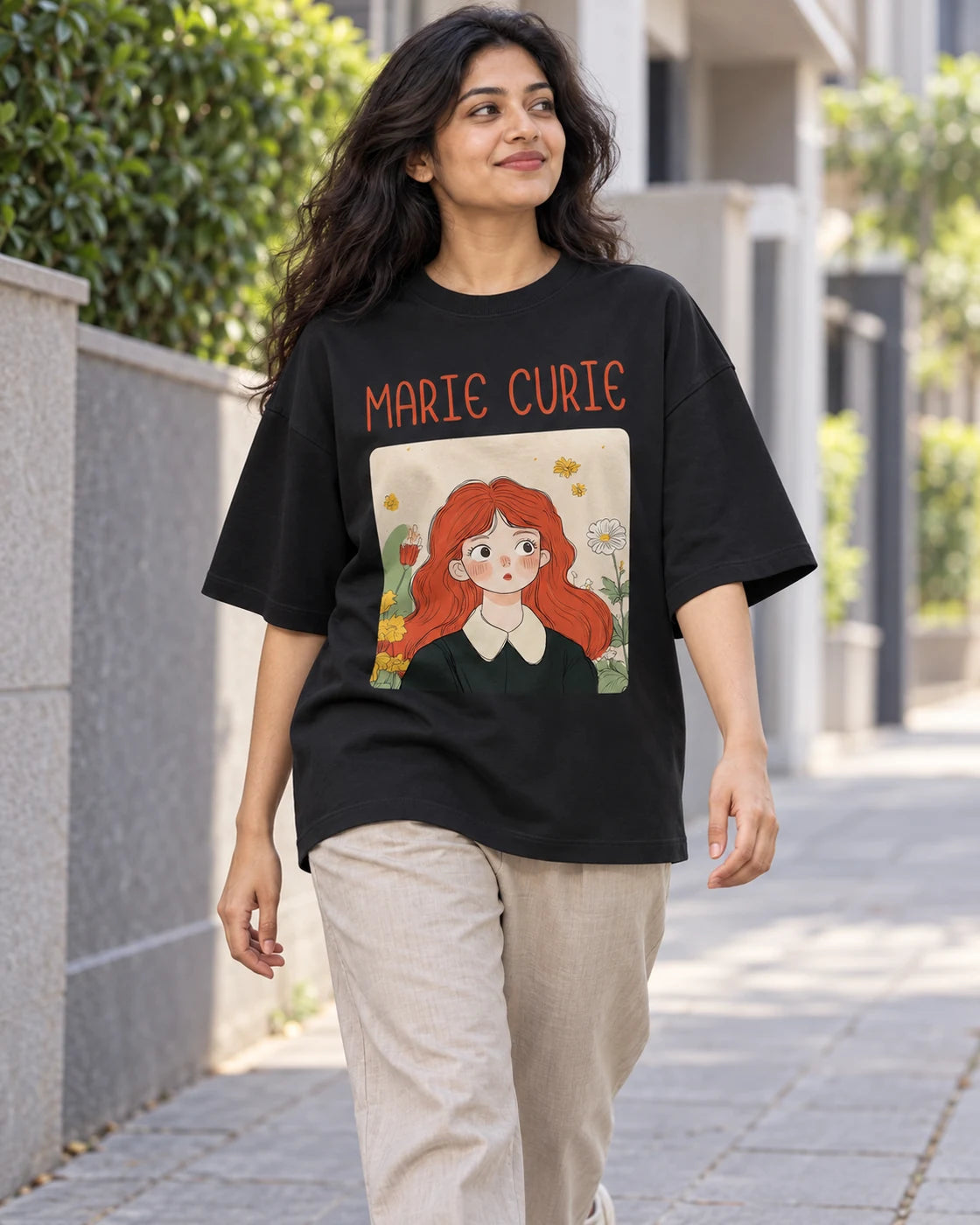 Model wearing the Marie Curie Genius Doodles oversized French terry T-shirt by Fourth Dimension Club on a city street