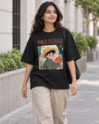 Model wearing the Pablo Picasso Genius Doodles oversized French terry T-shirt by Fourth Dimension Club on a city street
