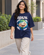 Model wearing the Earth Stellar Squad oversized French terry T-shirt in navy blue by Fourth Dimension Club on a city street