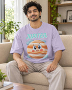 Model wearing the Jupiter Stellar Squad oversized French terry T-shirt in lavender by Fourth Dimension Club, seated on a sofa