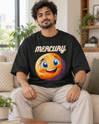 Model wearing the Mercury Stellar Squad oversized French terry T-shirt in black by Fourth Dimension Club, seated on a sofa