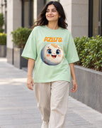 Model wearing the Pluto Stellar Squad oversized French terry T-shirt in jade by Fourth Dimension Club on a city street