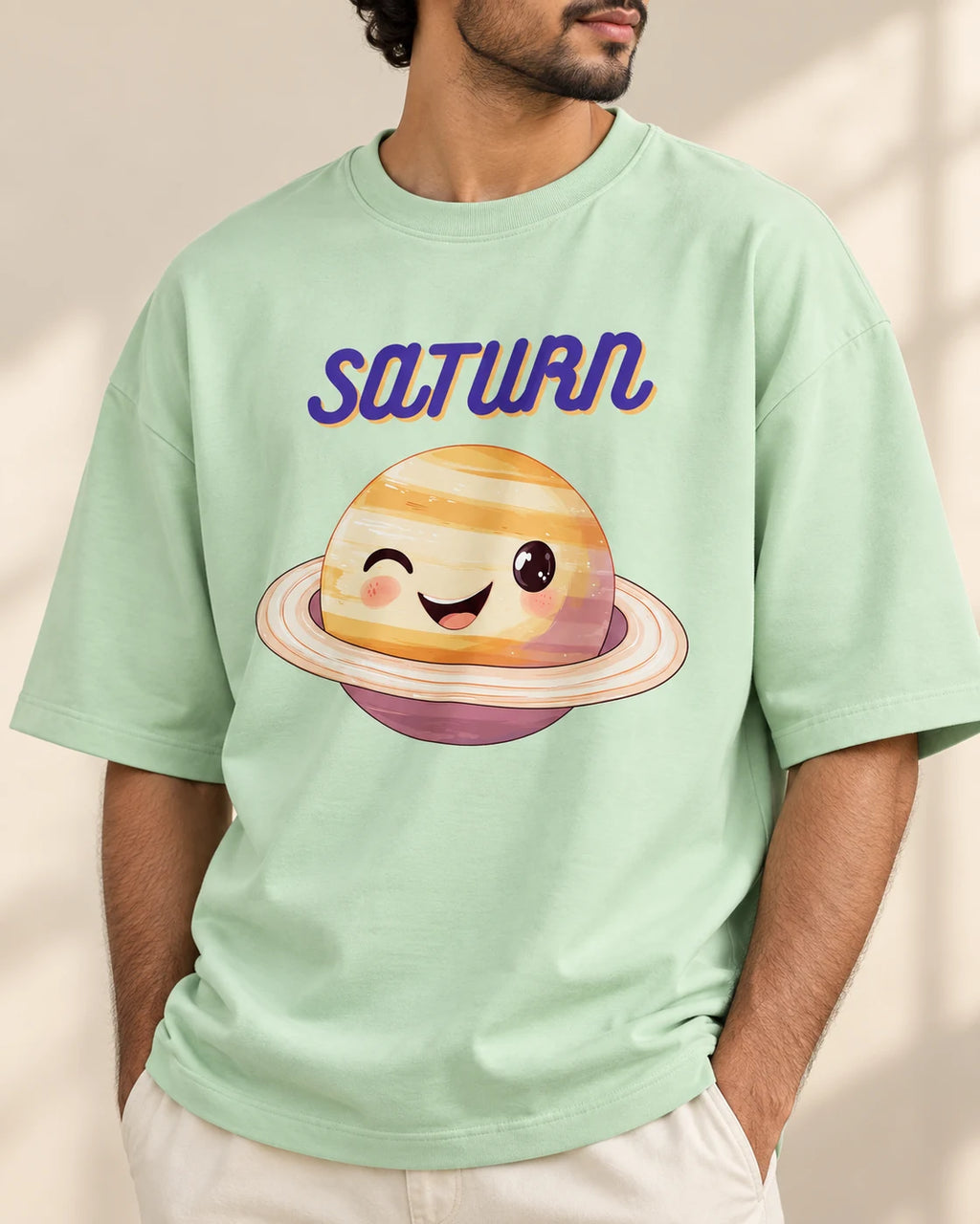 Close-up of the Saturn Stellar Squad print on a jade oversized French terry T-shirt, Fourth Dimension Club