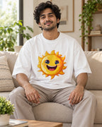 Model wearing the Sun Stellar Squad oversized French terry T-shirt in white by Fourth Dimension Club, seated on a sofa